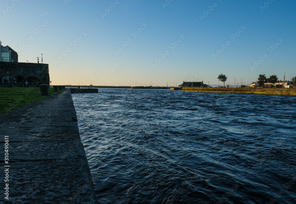 View of the river Corrib flowing through Galway city. Taken on a sunny summer morning at sunrise.