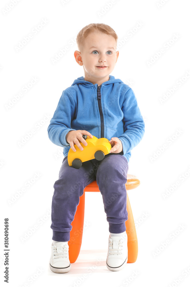 Portrait of cute little boy with toy car on white background