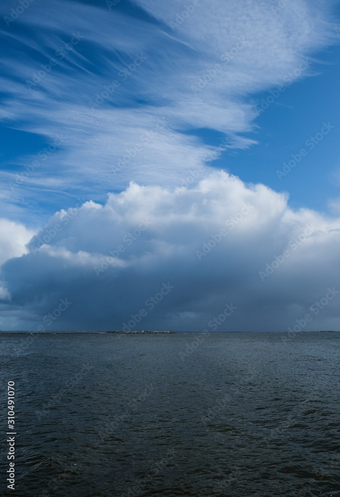 Rain cloud and rain fall over the water of Galway bay, taken on a summer day from Salthill Promenade, Ireland.