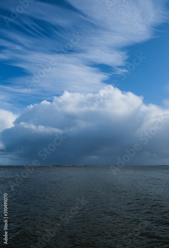 Rain cloud and rain fall over the water of Galway bay, taken on a summer day from Salthill Promenade, Ireland.