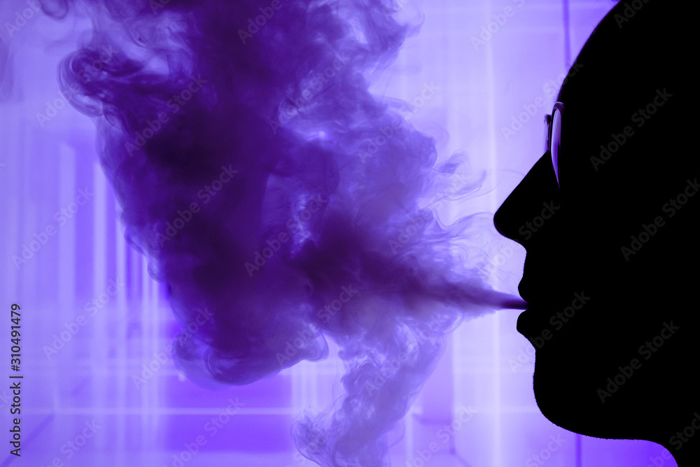 Man with electronic cigarette and smoke vapping with neon lights background