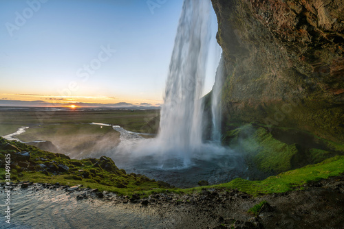 The famous Seljalandsfoss waterfall part of the golden circle tour in Iceland. Sunset during evening hours with no people around. Iceland air, travelocity and exploring concept.