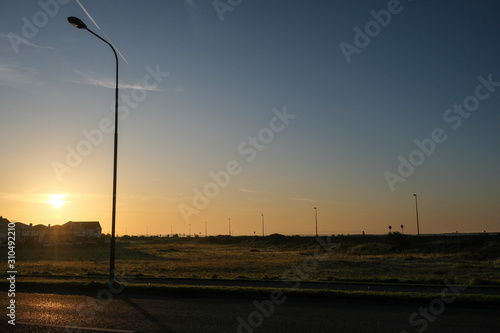 Sunlit road along the Wild Atlantic Way, going along Salthill promenade near Galway, in ireland. Tekan at sunrise on a sunny day. photo