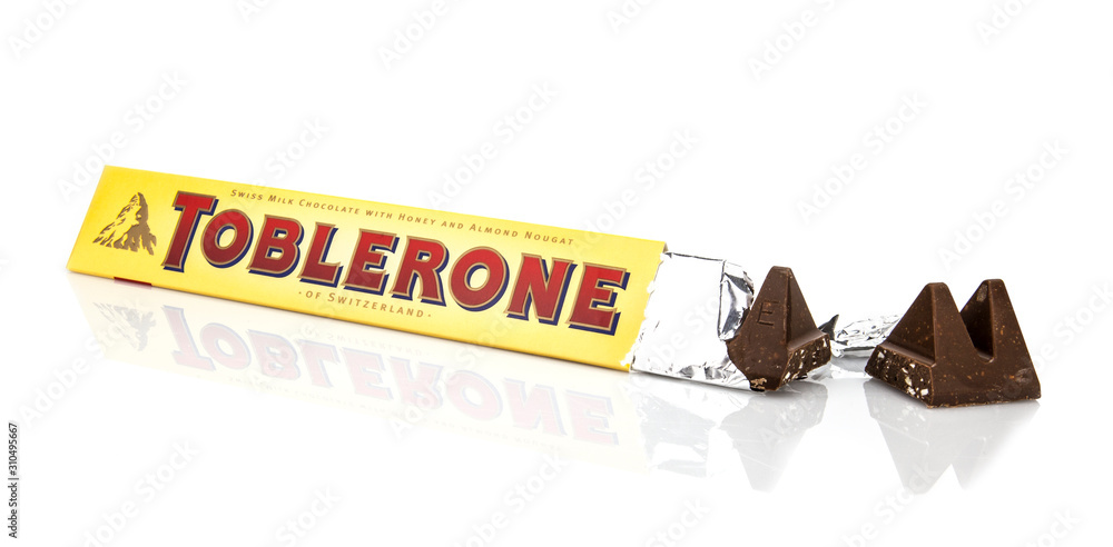An open packet of Toblerone - Swiss milk chocolate with honey and almond  nougat on a white background with chocolate bar broken open. Photos | Adobe  Stock
