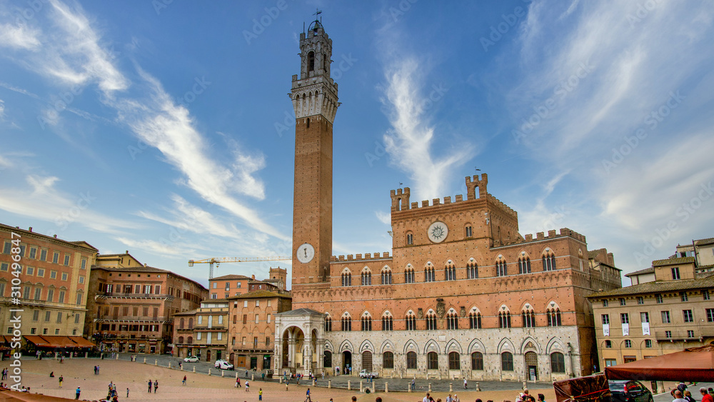 Siena, Toscana, Italy - November 2019: Siena clock tower in Siena square Basilica Cateriniana di San Domenico