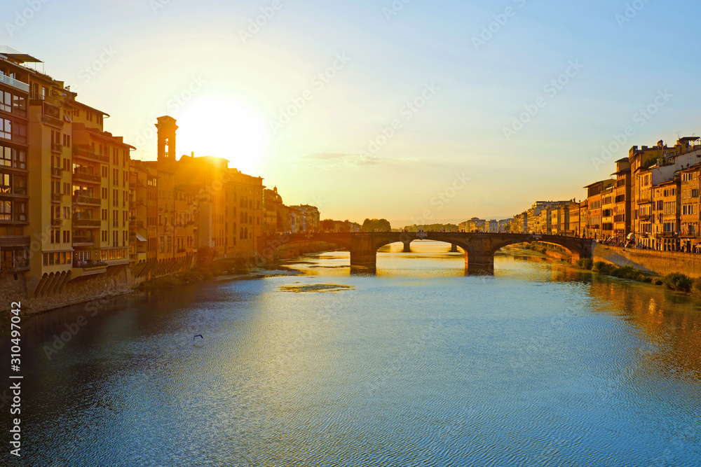 Beautiful landscape view of amazing Florence city with famous medieval stone bridge Ponte Vecchio and the Arno River at sunset light. Firenze scenery panorama, Italy Europe. Italian summer vacation.