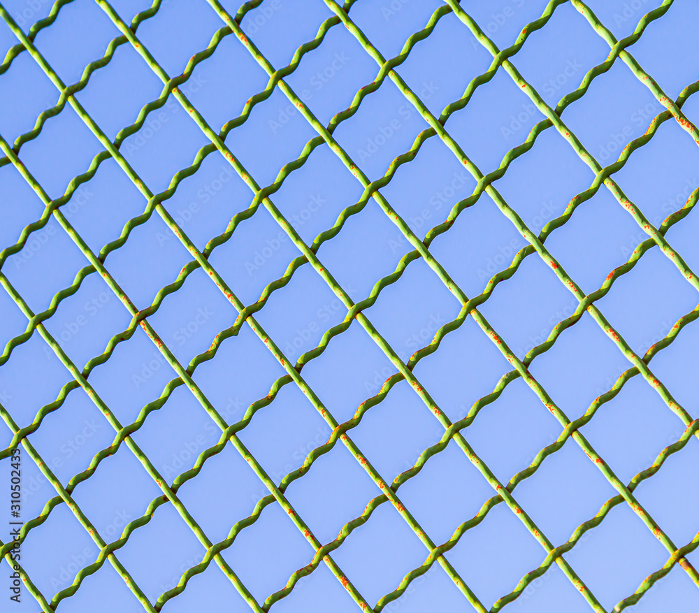 Fototapeta premium Metal mesh against the blue sky.