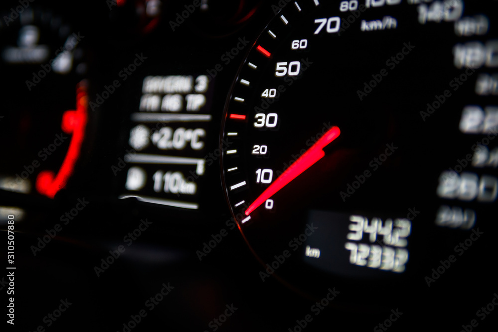 Close up shot of a speedometer in a car. Car dashboard. Dashboard details with indication lamps.Car instrument panel. Dashboard with speedometer, tachometer, odometer. Car detailing.