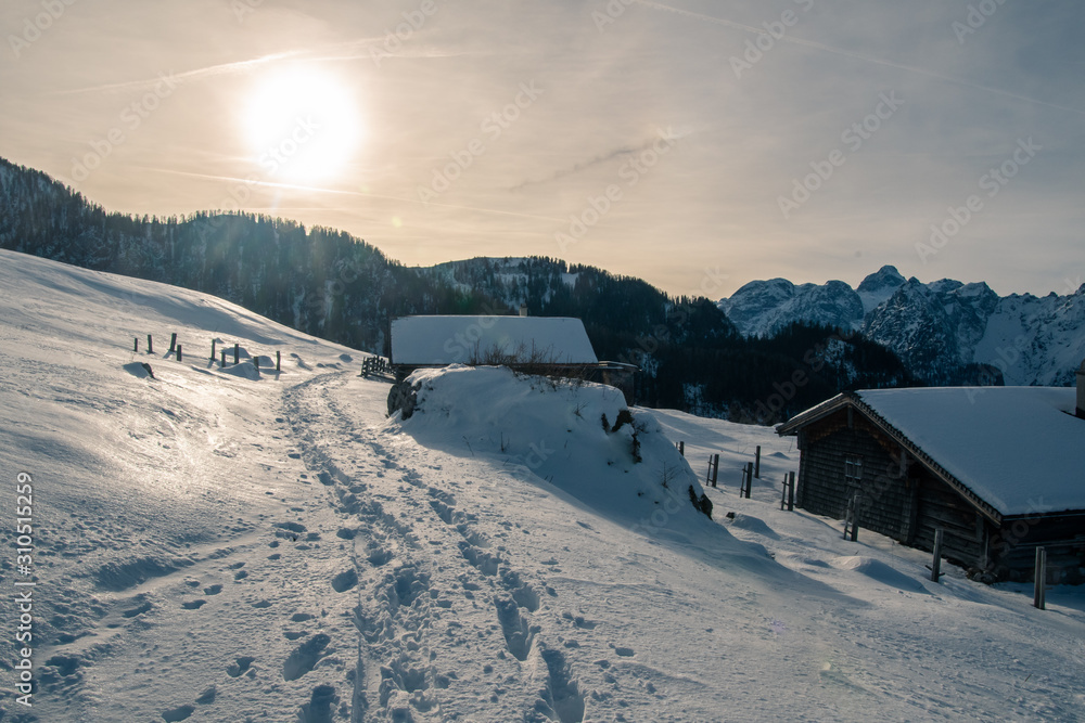 Spure imn Schnee im Gegenlicht mit Almhütten Spure imn Schnee im Gegenlicht mit Almhütten