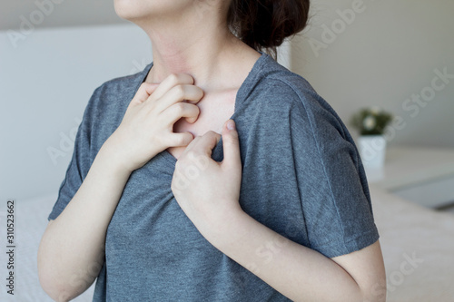 Young woman scratch the itch on her neck, Healthcare concept. photo