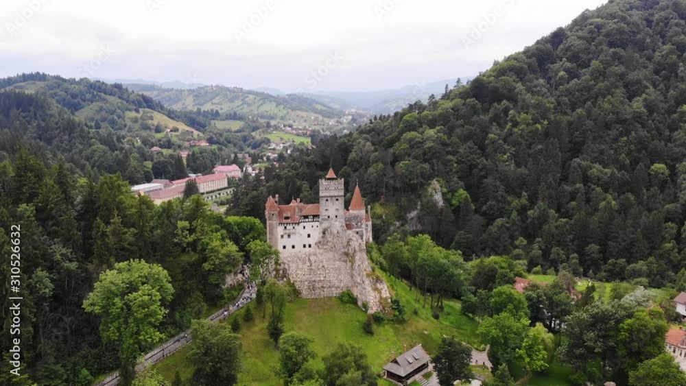 aero. panoramic view of the ancient Bran castle on a hill , Dracula Castle, Transylvania, Brasov, Romania. at the foot of the castle there is a small town. summer day aero. panoramic view of the ancient Bran castle on a hill , Dracula Castle, Transylvania, Brasov, Romania. at the foot of the castle there is a small town. summer day