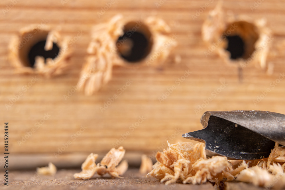 Drilling with a drill bit into wood. Small carpentry work in a carpentry workshop. Drilling with a drill bit into wood. Small carpentry work in a carpentry workshop.
