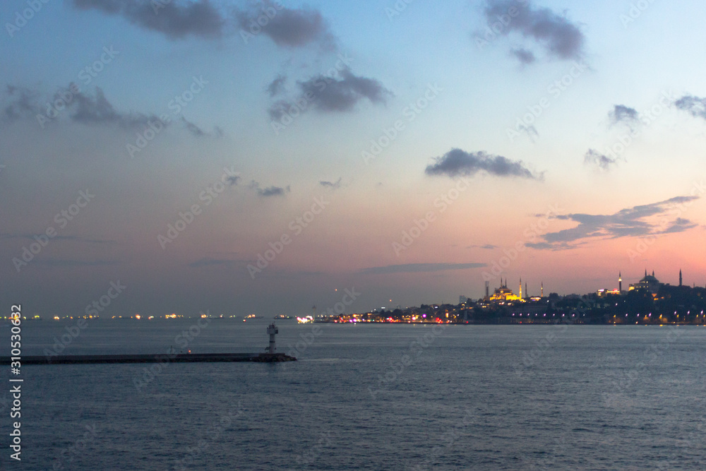 Sea port. Bosphorus Strait. View of Istanbul. Coast resort town. Ferry on the water. Ship at sea. Sunset sky. Sky gradient. Seascape in Istanbul. City on the horizon. Pink and blue shades. Sea port. Bosphorus Strait. View of Istanbul. Coast resort town. Ferry on the water. Ship at sea. Sunset sky. Sky gradient. Seascape in Istanbul. City on the horizon. Pink and blue shades.