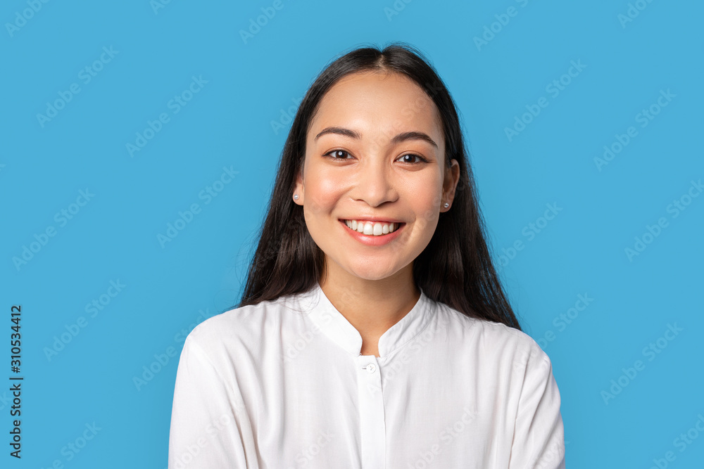 Freestyle. Young woman wearing shirt standing isolated on blue smiling happy close-up Freestyle. Young woman wearing shirt standing isolated on blue smiling happy close-up