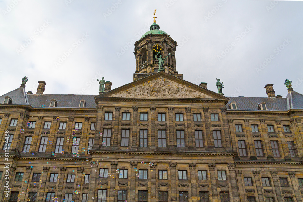Interesting view of top part of The Royal Palace in Dam Square with bubble blower, Amsterdam, Netherlands.