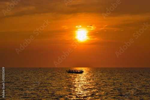 Lonely boat on a wide sea during beautiful orange sunset in Asia © MartinZizlavsky