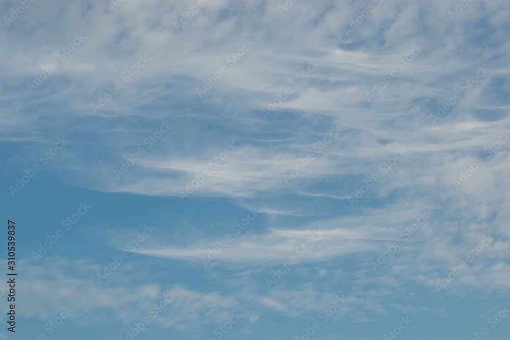 Cirrus clouds sprawling across the blue sky with beautiful white flakes and threads Cirrus clouds sprawling across the blue sky with beautiful white flakes and threads