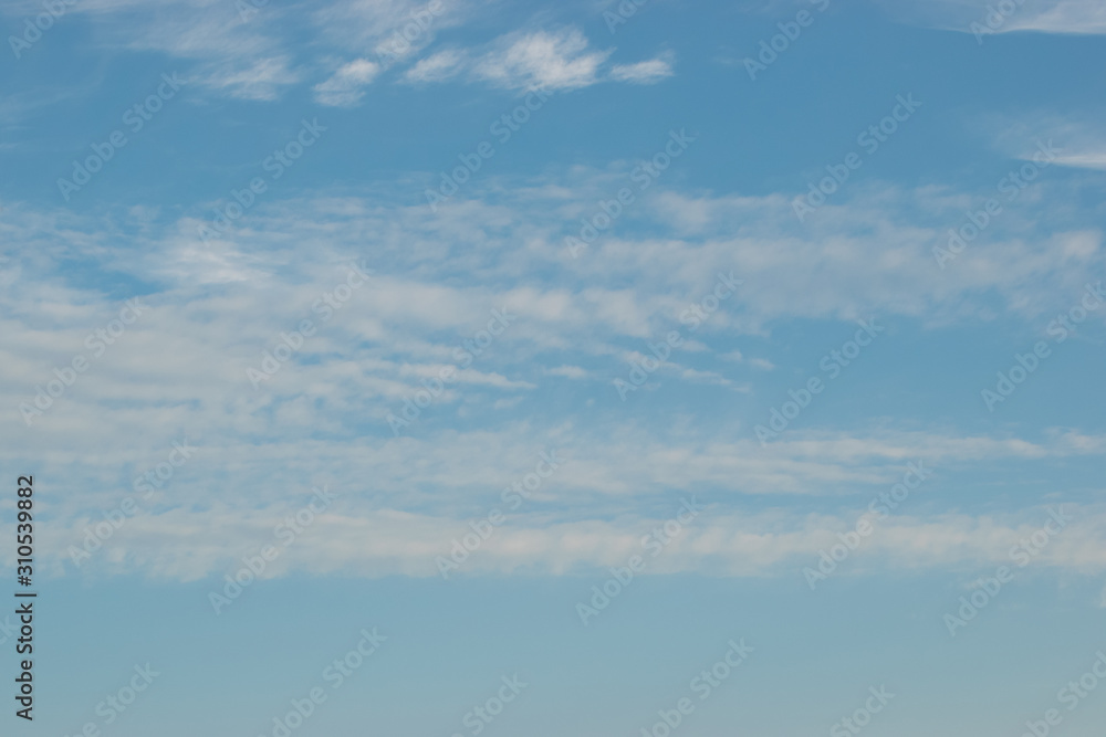 Cirrus clouds sprawling across the blue sky with beautiful white flakes and threads Cirrus clouds sprawling across the blue sky with beautiful white flakes and threads