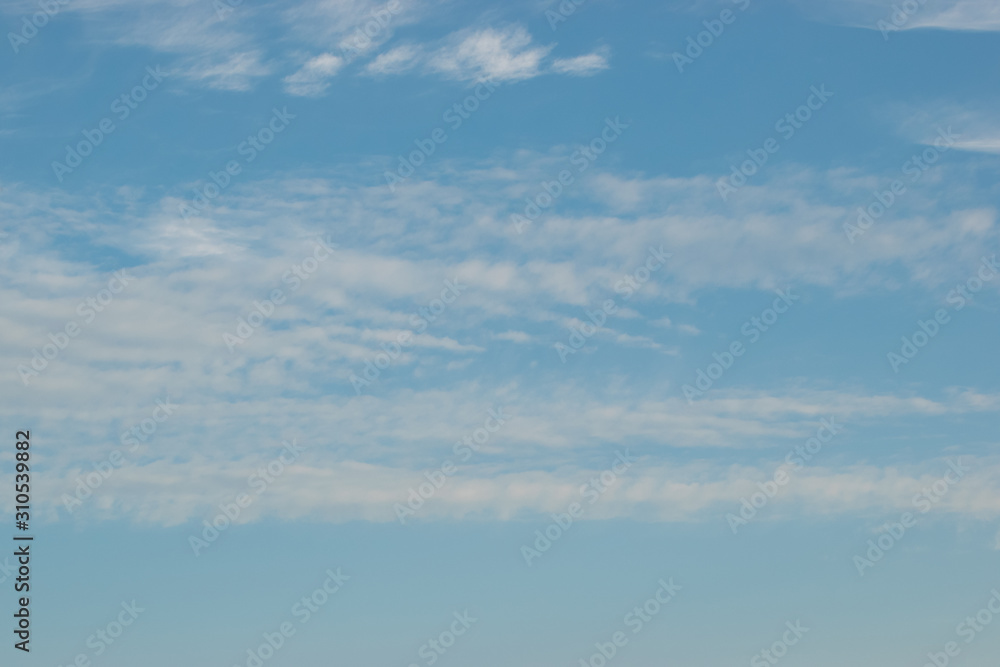 Cirrus clouds sprawling across the blue sky with beautiful white flakes and threads