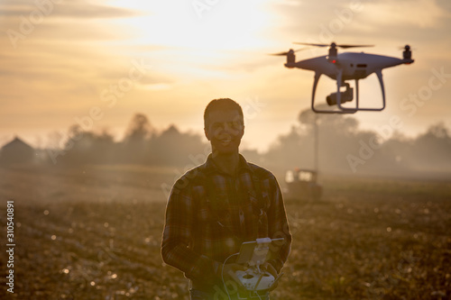 Farmer driving drone above field