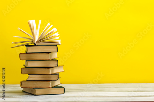 Open book, hardback books on wooden table. Back to school. Copy space.