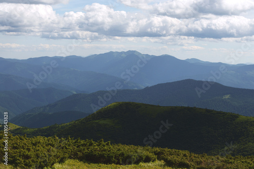 Fototapeta Naklejka Na Ścianę i Meble -  Beautiful mountain landscape, with mountain peaks covered with forest and cloudy sky.Ukrainian Carpathian Mountains