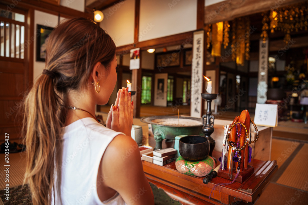 Two Japanese women kneeling in Buddhist temple, praying. Two Japanese women kneeling in Buddhist temple, praying.