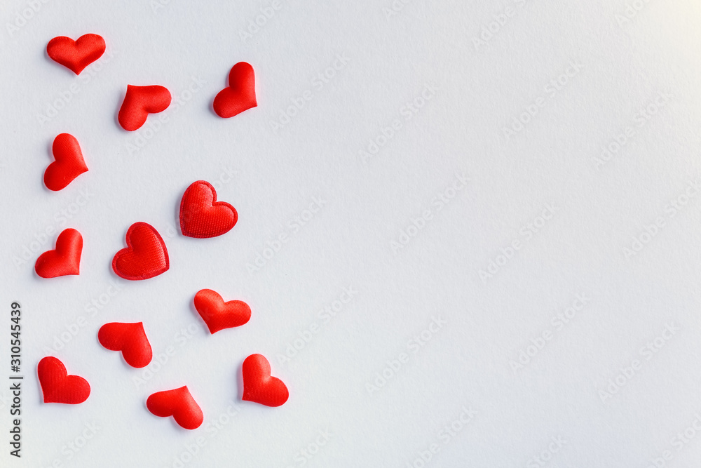 Festive composition from red hearts scattered on white background, valentines day concept, copy space Festive composition from red hearts scattered on white background, valentines day concept, copy space