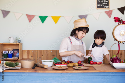 Japanese woman and boy standing in a farm shop, preparing food. photo