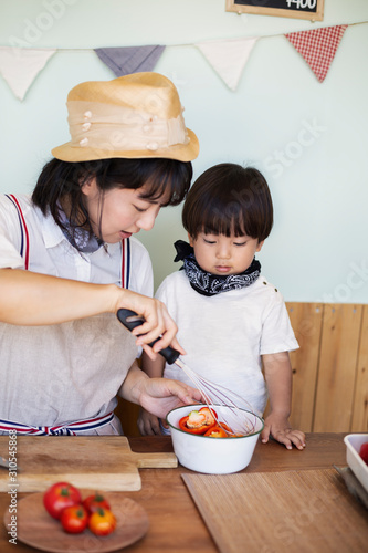 Japanese woman and boy standing in a farm shop, preparing food. photo