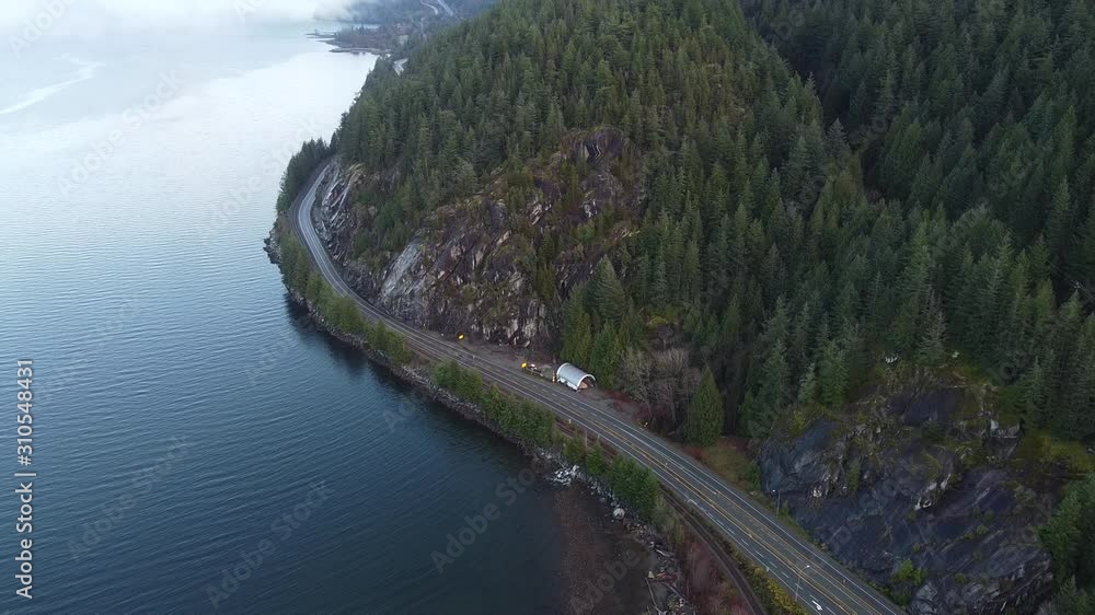 Mountains covered with the pine trees and a highway on the edge of the river Mountains covered with the pine trees and a highway on the edge of the river