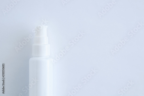 White plastic bottle with dispenser closeup. White background.
