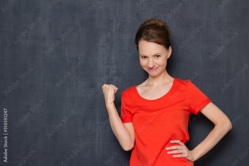 Portrait of happy young woman smiling and raising clenched fist up Portrait of happy young woman smiling and raising clenched fist up