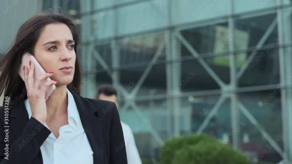 Young Business People On The Street. They Are Walking Down The Street. Girl Talking On The Phone. Young Business People On The Street. They Are Walking Down The Street. Girl Talking On The Phone.