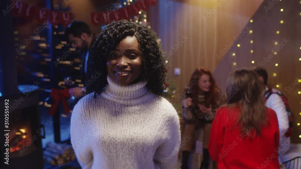Charming young african woman with curly black hair smiling happy staying at Christmas party winter feast celebration with friends. Best friends on holiday night party. Charming young african woman with curly black hair smiling happy staying at Christmas party winter feast celebration with friends. Best friends on holiday night party.
