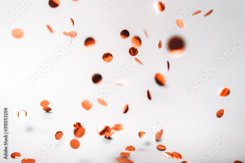 Rose gold falling confetti on White background. Holiday concept.