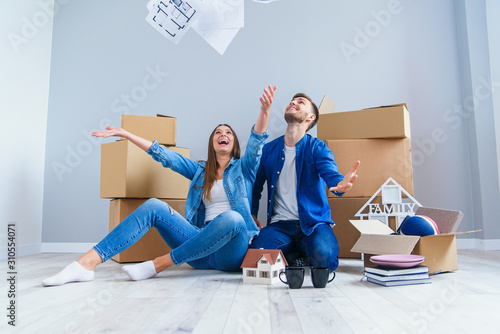 Slika na platnu Happy cheerful couple in love having fun together in their own new flat after re