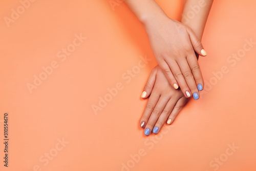 Manicure in trendy colors: coral, metallic yellow and mint on colorful background. Flat lay style.