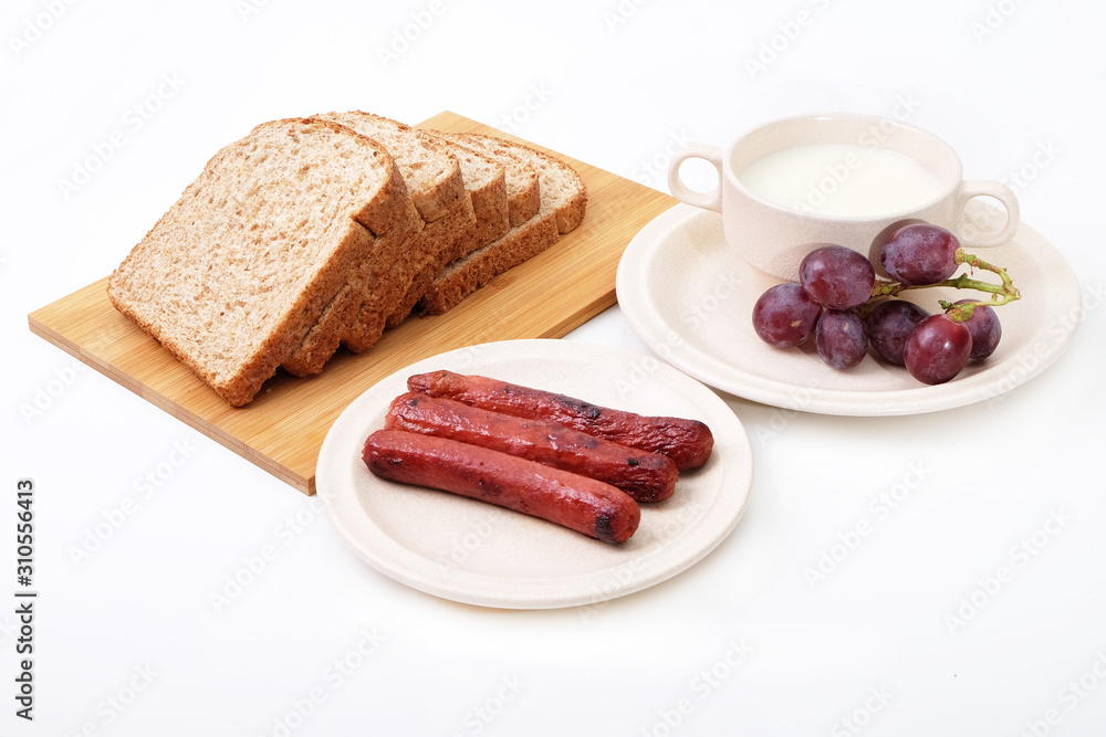 Whole grain bread, sausages and grapes serve with milk.. Whole grain bread, sausages and grapes serve with milk..