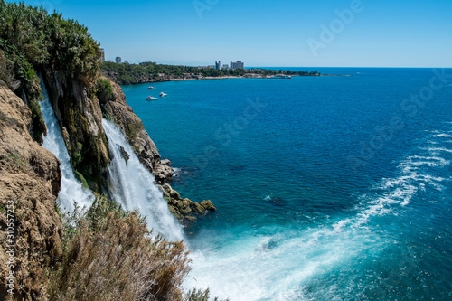 Waterfall Duden at Antalya turkey top view on the mountain with coast ferry boat on blue sea and harbor city background - Beautiful antalya beach Turkey landscape travel landmark