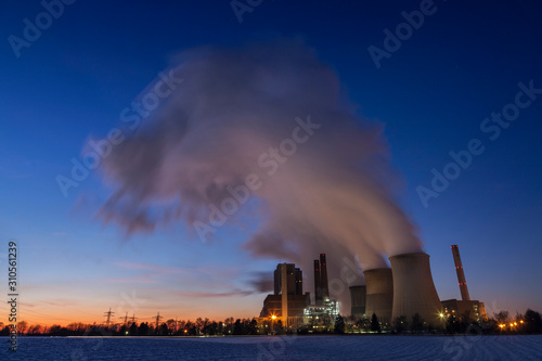 Coal-fired power plant Eschweiler-Weisweiler, Germany, at dusk in winter. Steam rising from coolers.