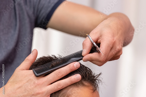 Hairdresser cutting a child's hair. Use the comb to guide the cut