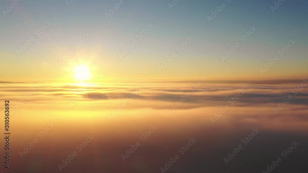 High altitude drone aerial flight over thick clouds with view of the orange sun shining High altitude drone aerial flight over thick clouds with view of the orange sun shining