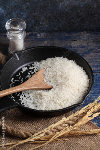 Fototapeta Close up white rice in measuring cup on table, Thai Jasmine rice in rustic kitch