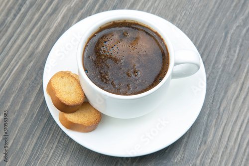 white Cup of black coffee with biscuits on a wooden frame