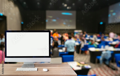 Obraz na plátně Blank screen desktop computer on the Abstract blurred photo of conference hall or seminar room with attendee background