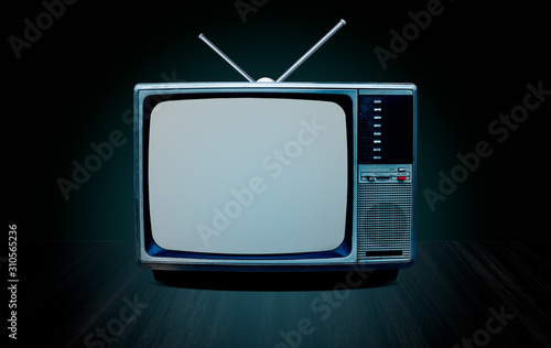 vintage old television receiver and antenna on table front gradient green wall background,vintage tv with cut screen on perspective wooden floor,blue glow and dark tone style