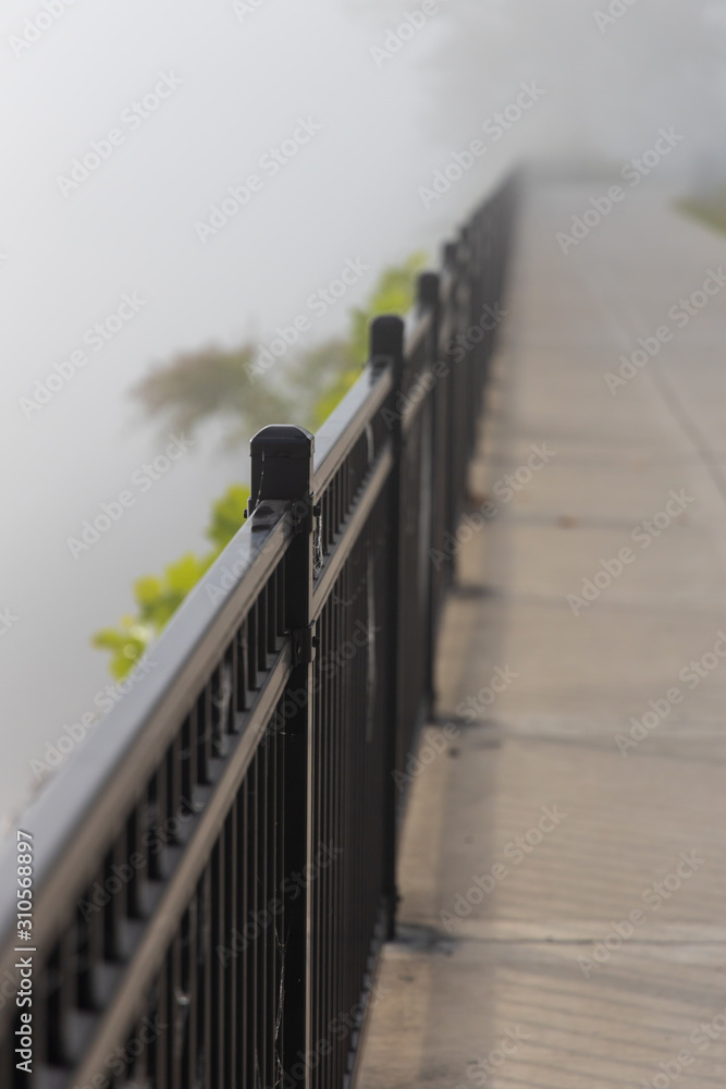 Obraz premium Sidewalk in the fog along lake