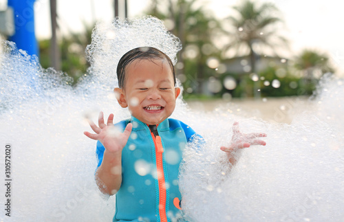 Canvas Portraits of happy little Asian baby boy smiling having fun in Foam Party at the pool outdoor