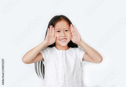 Portrait of happy little child girl gestures playing peekaboo over white background. Kid posture open hands from eyes with smile.